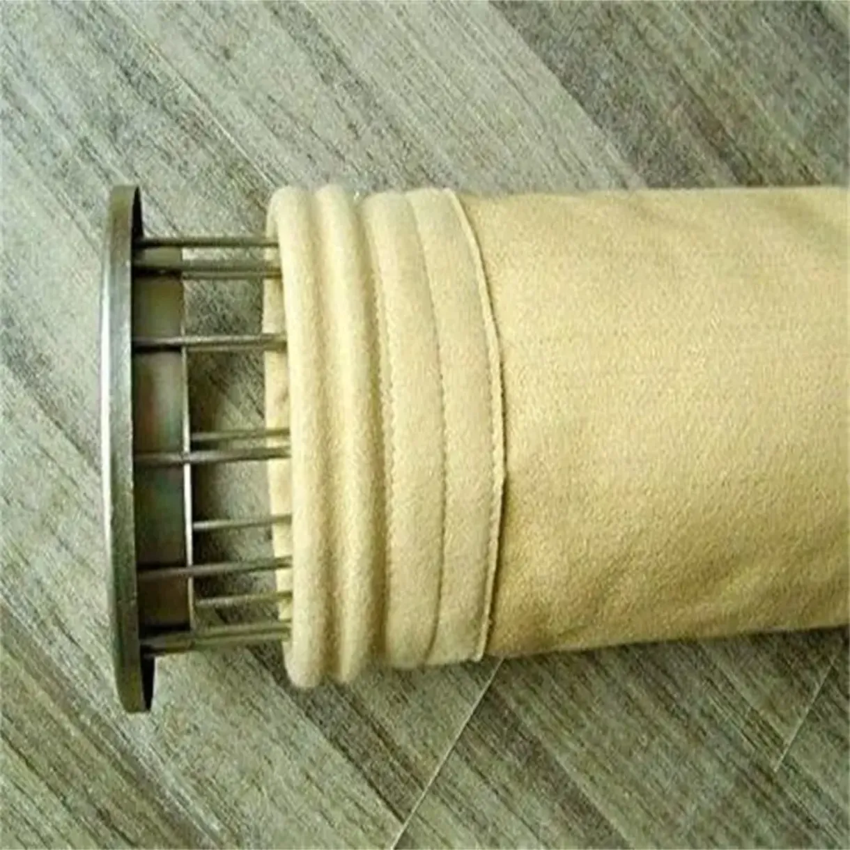 Manche filtrante industrielle en tissu beige montée sur son armature métallique de soutien.